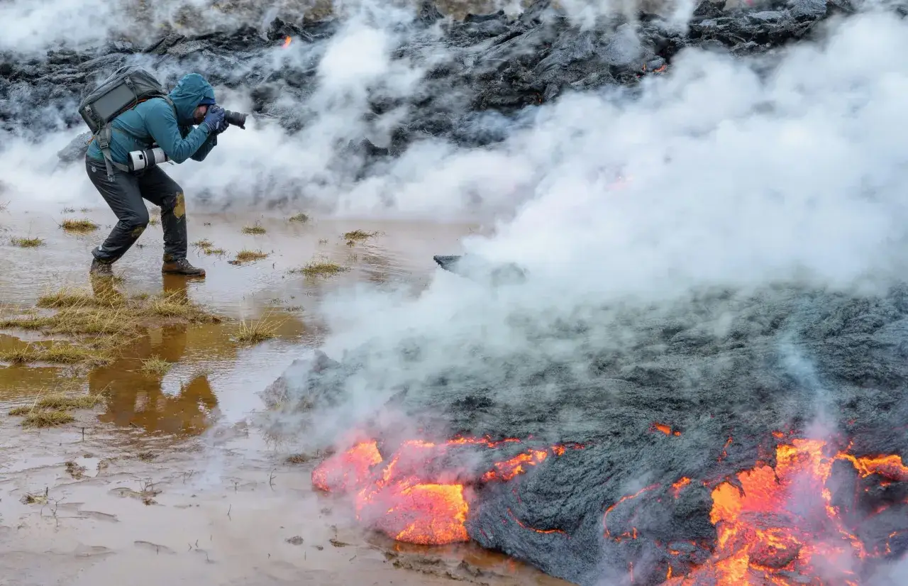 Robert Landsburg, photographe intr&eacute;pide, capture la puissance brute d'une coul&eacute;e de lave incandescente, entour&eacute; de fum&eacute;e et de vapeur.
