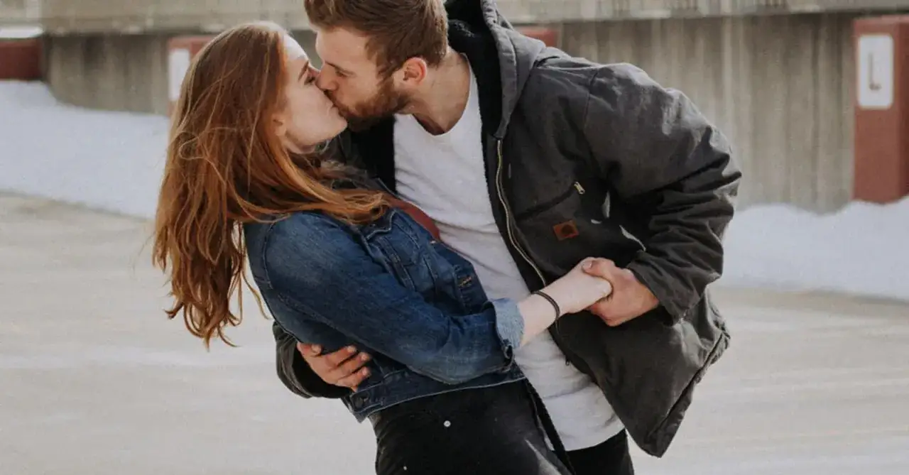 Een stel kust gepassioneerd, hun handen verstrengeld. Dit is wat ontgroend liefde betekent: pure, onbevangen genegenheid.