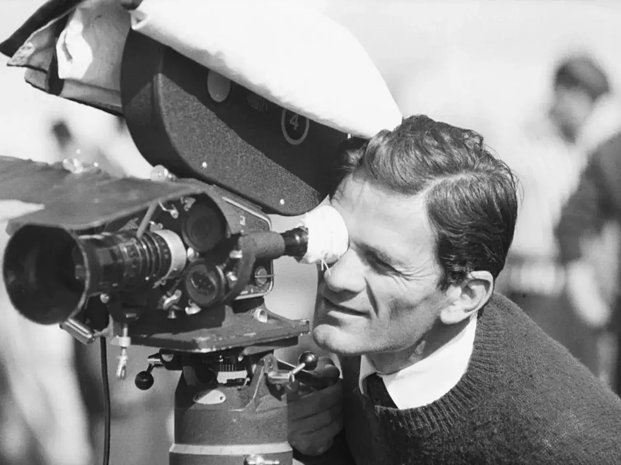 Pier Paolo Pasolini, con lo sguardo fisso nel mirino, cattura immagini per le sue opere.