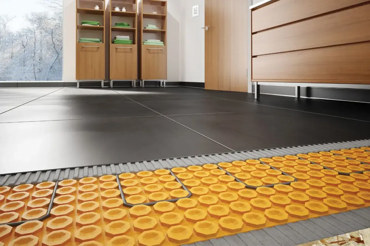 Coupe d'un carrelage moderne avec syst&egrave;me de chauffage au sol int&eacute;gr&eacute;, promettant un confort douillet m&ecirc;me par temps froid.