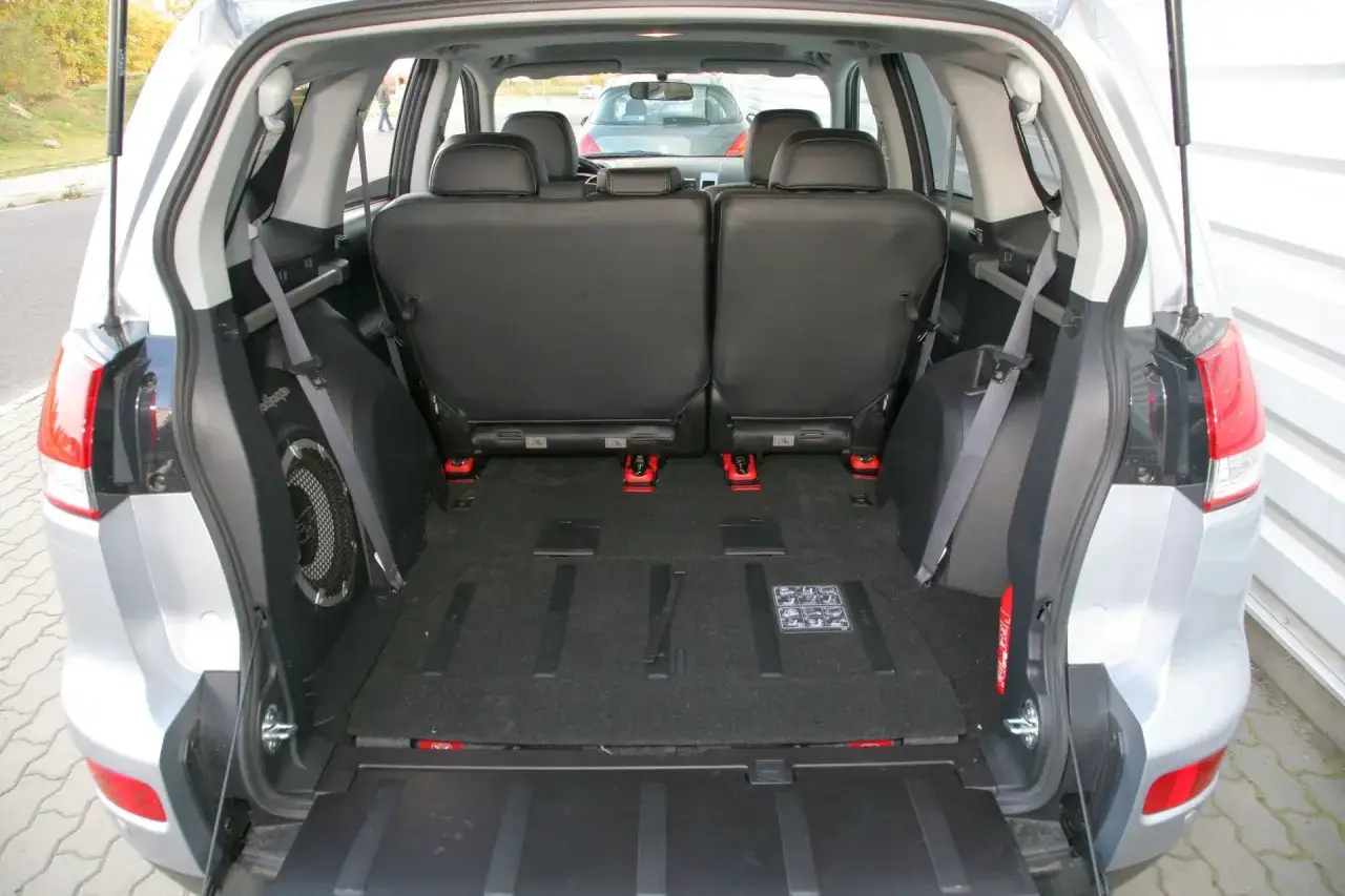 Wnętrze Citroen C-Crosser z rozłożonymi tylnymi siedzeniami i zamontowanym subwooferem.