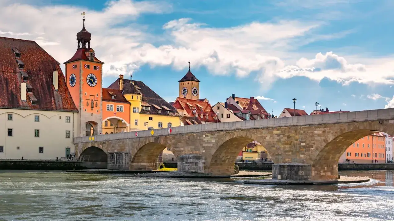 Regensburg: Steinerne Br&uuml;cke, historische Geb&auml;ude mit Uhrt&uuml;rmen und die Donau. Perfekt, um zu sehen, was tun in Regensburg!