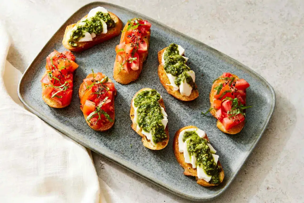 Leckere Crostini Variationen: ger&ouml;stetes Brot mit Tomaten und Basilikum oder Mozzarella und Pesto.