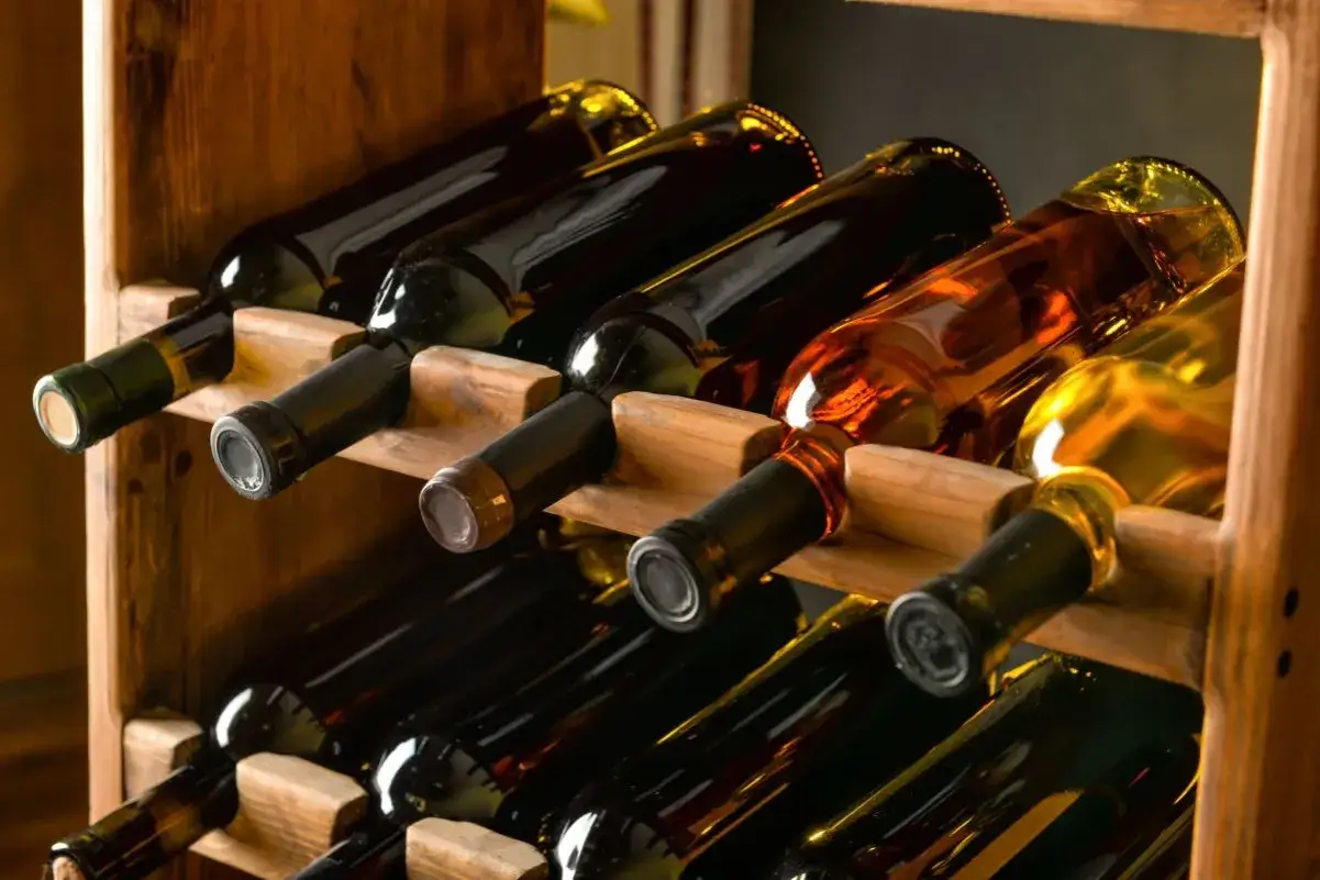 Drewniany stojak na wino diy z butelkami czerwonego i białego wina.