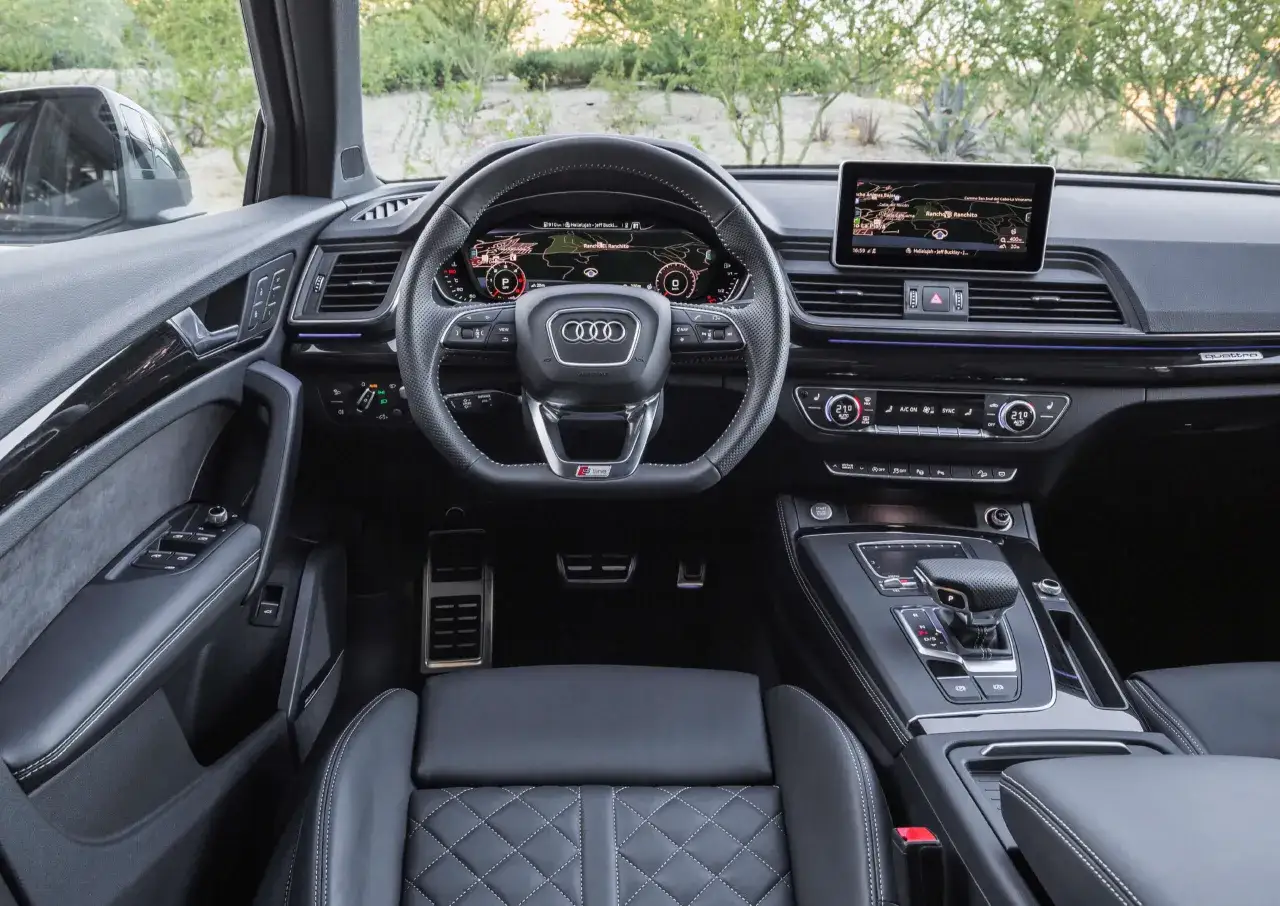 Wnętrze Audi Q5, z cyfrowymi zegarami i ekranem nawigacji. Wiele osób szuka audi q5 opinie, by poznać wrażenia z jazdy tym SUV-em.
