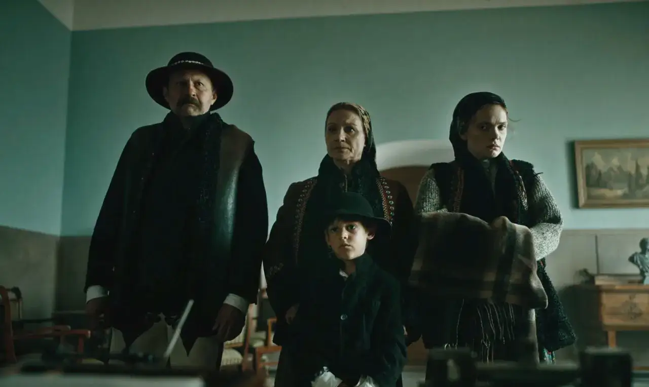 Rodzina w tradycyjnych strojach, z chłopcem na pierwszym planie, w scenie z filmu 