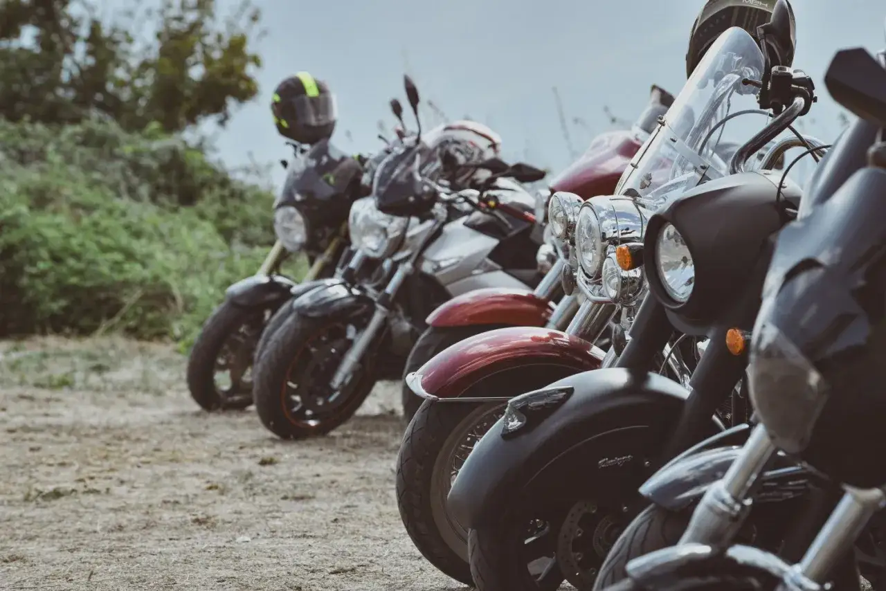 Parcheggio di moto per una festa bikers. Caschi e cromature brillano sotto il cielo.