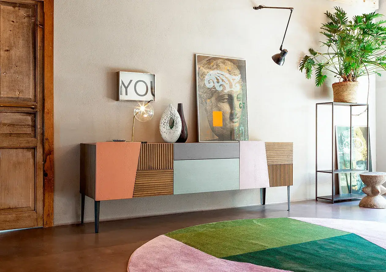 Come arredare una madia moderna: un mobile colorato con decorazioni geometriche, lampada di design, vasi e quadri astratti.