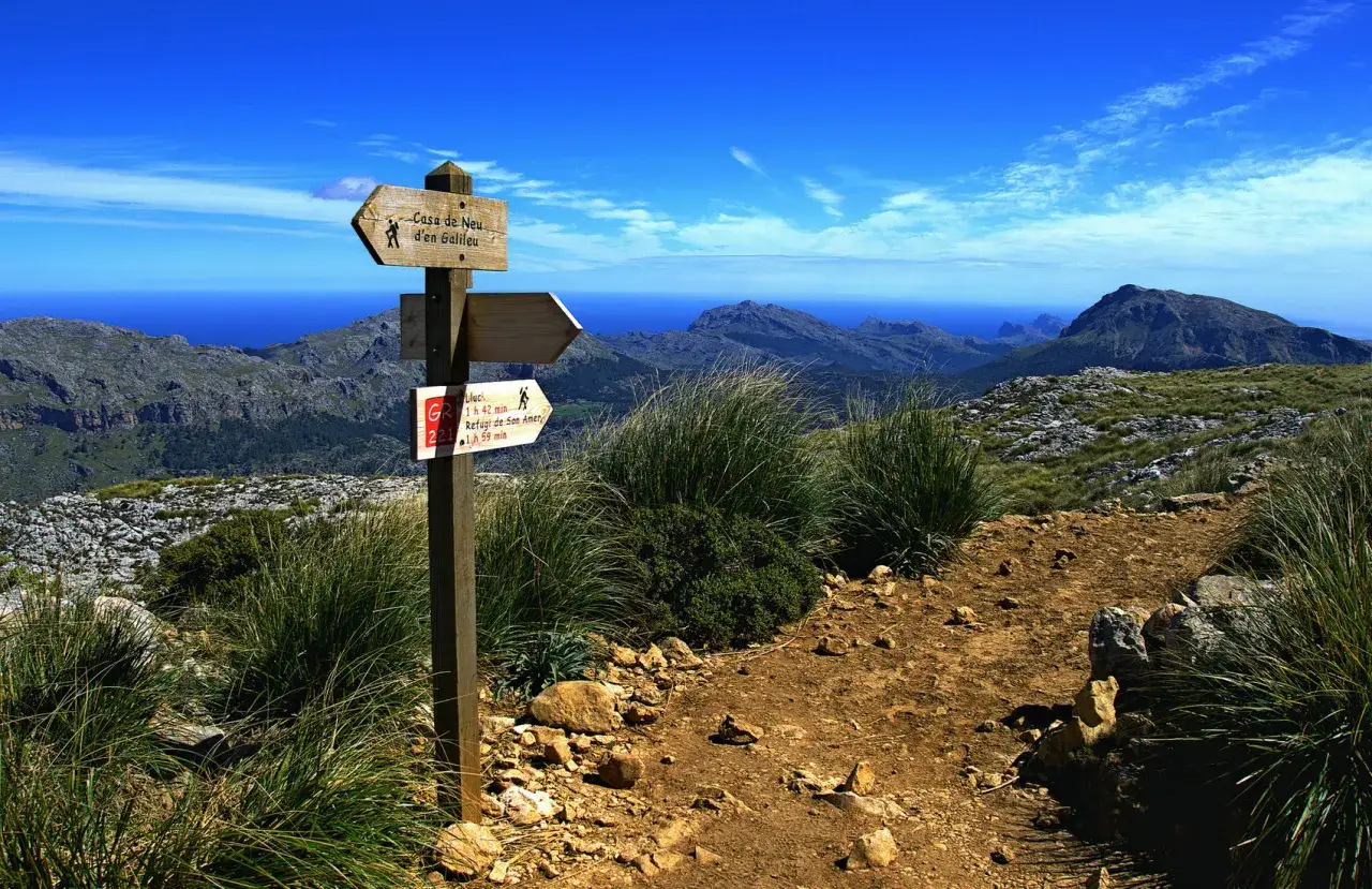 Szlak w górach Serra de Tramuntana na Majorce. Znak drogowy wskazuje trasy, idealne na zimowe wędrówki.