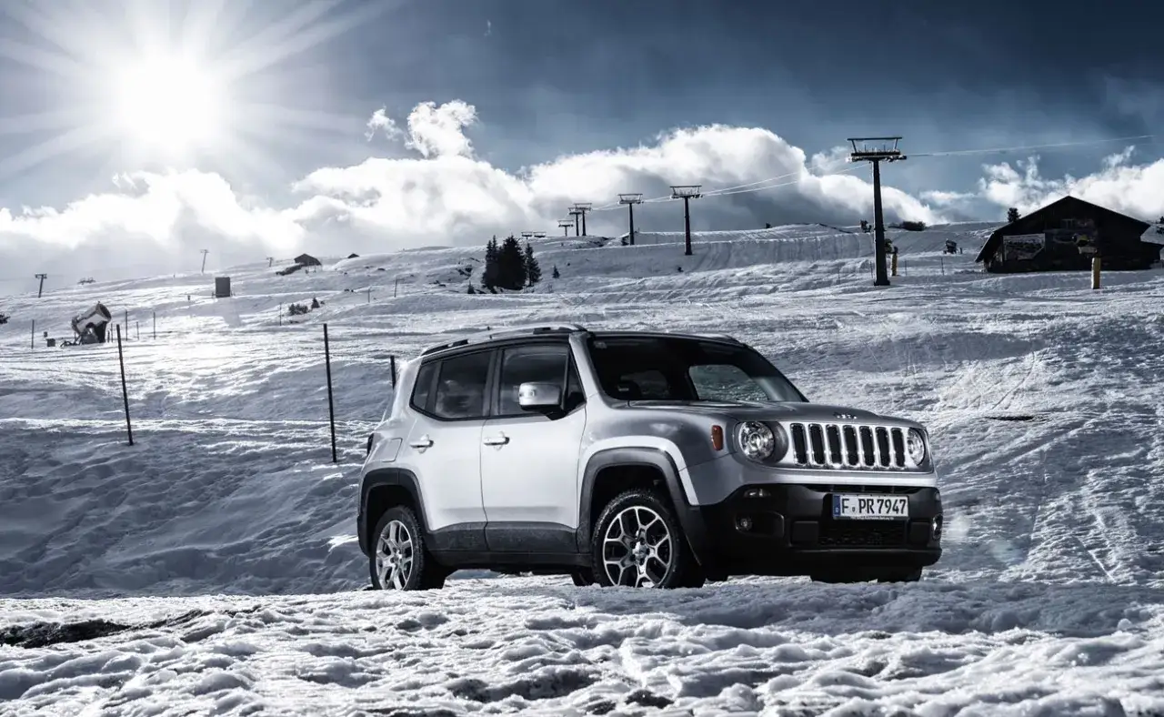 Un coche plateado listo para la aventura en la nieve, con telesillas y monta&ntilde;as nevadas de fondo. Estos coches de monta&ntilde;a son perfectos para explorar.