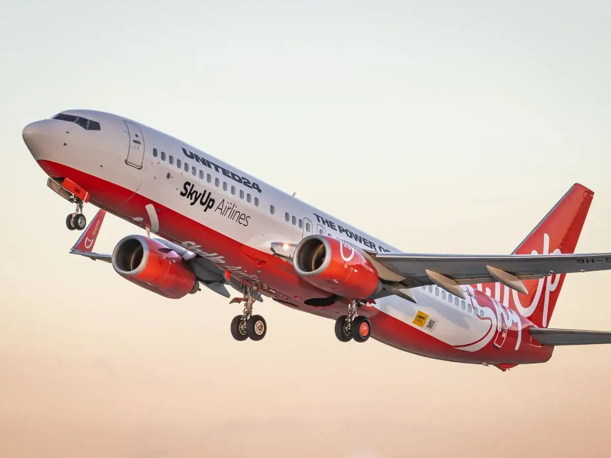 Samolot SkyUp Airlines z czerwonymi silnikami wznosi się w powietrze.