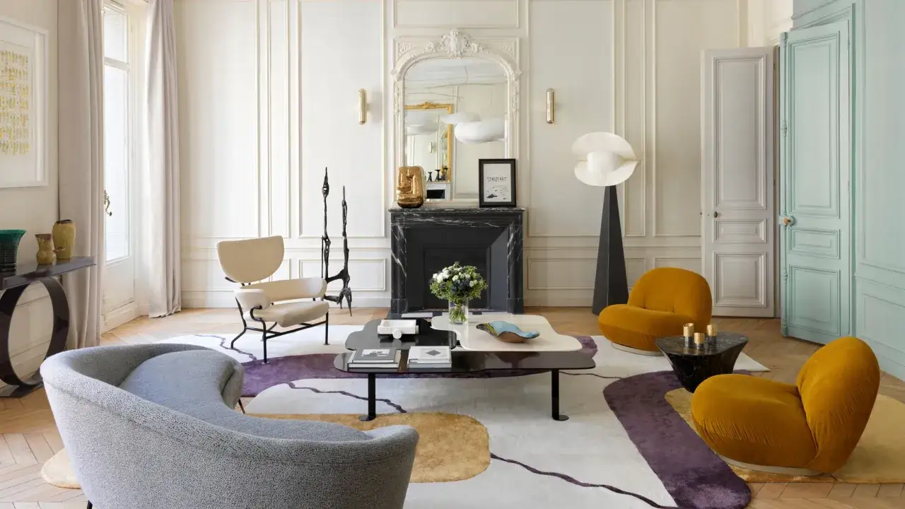 Elegancki salon w stylu francuskim z designerskimi meblami, abstrakcyjnym dywanem i ozdobnym kominkiem.
