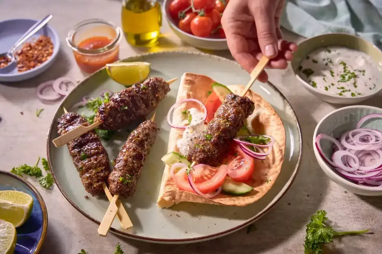 Pyszny kebab na patyku, podany z warzywami i sosem. Idealny na szybki posiłek.