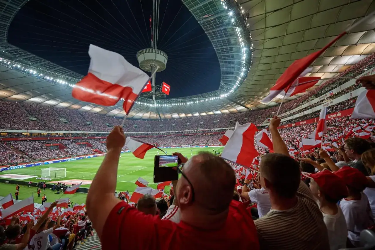 Tłumy kibiców na PGE Narodowy podczas meczów, machają polskimi flagami. Atmosfera jest gorąca!