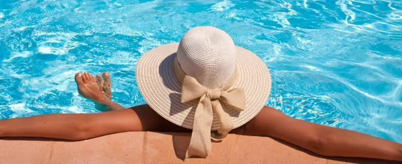 Disfruta del verano con este sombrero chic y consejos para como cuidar el pelo en verano. Relájate en la piscina.