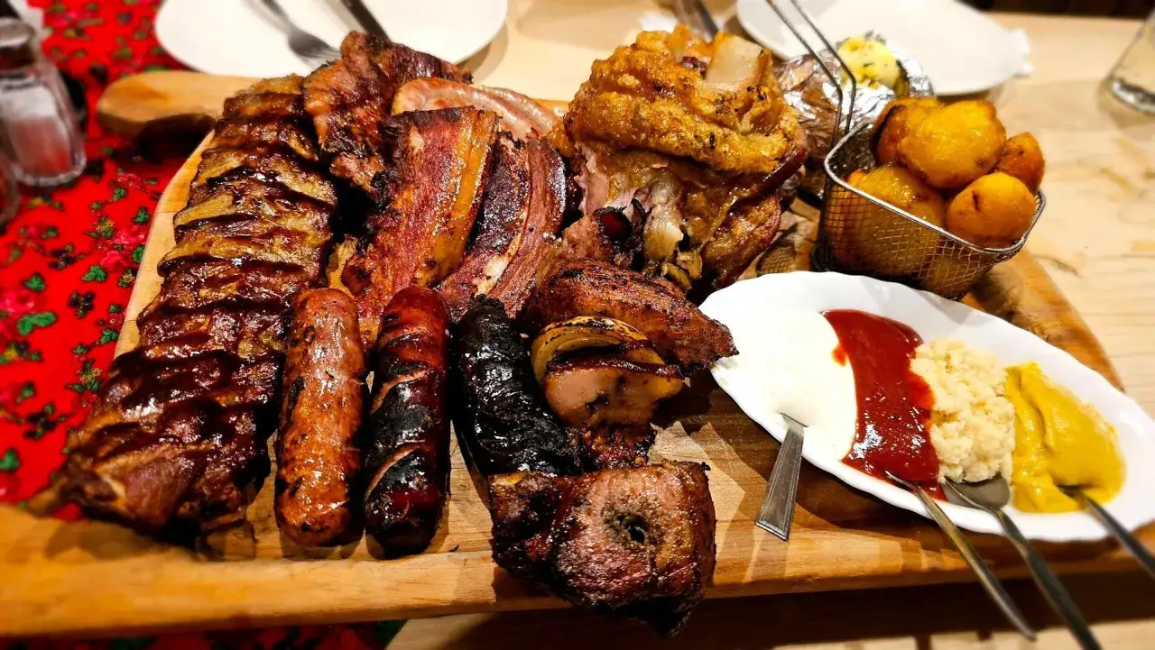 Obfite mięsne danie z karczmy bac&oacute;wka Zakopane. Menu pełne grillowanych żeberek, kiełbasek, golonki i dodatk&oacute;w.