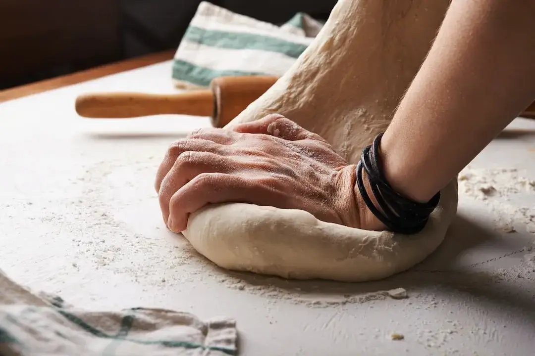 rozciąganie ciasta na pizzę dłońmi