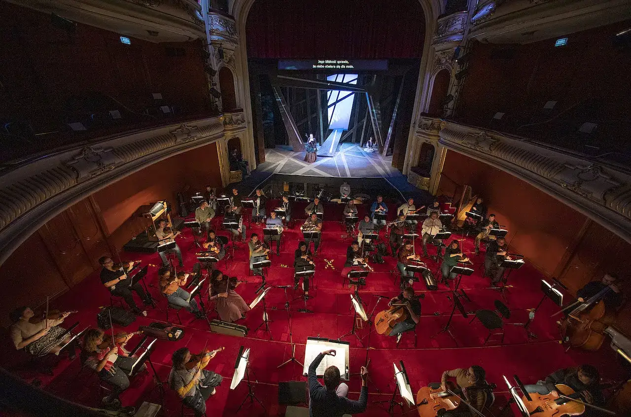 Orkiestra przygotowuje się do spektaklu. Widać scenę z aktorami i muzyków z instrumentami. Bytom teatr repertuar w pełnej krasie.