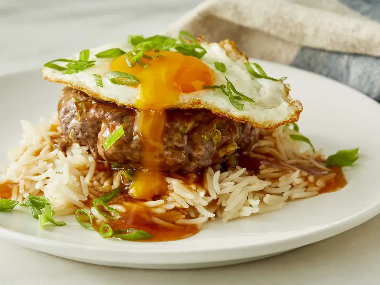 En l&auml;cker loco moco med en saftig k&ouml;ttpuck, ris, en stekt &auml;gg med rinnig gula och gr&ouml;n l&ouml;k.