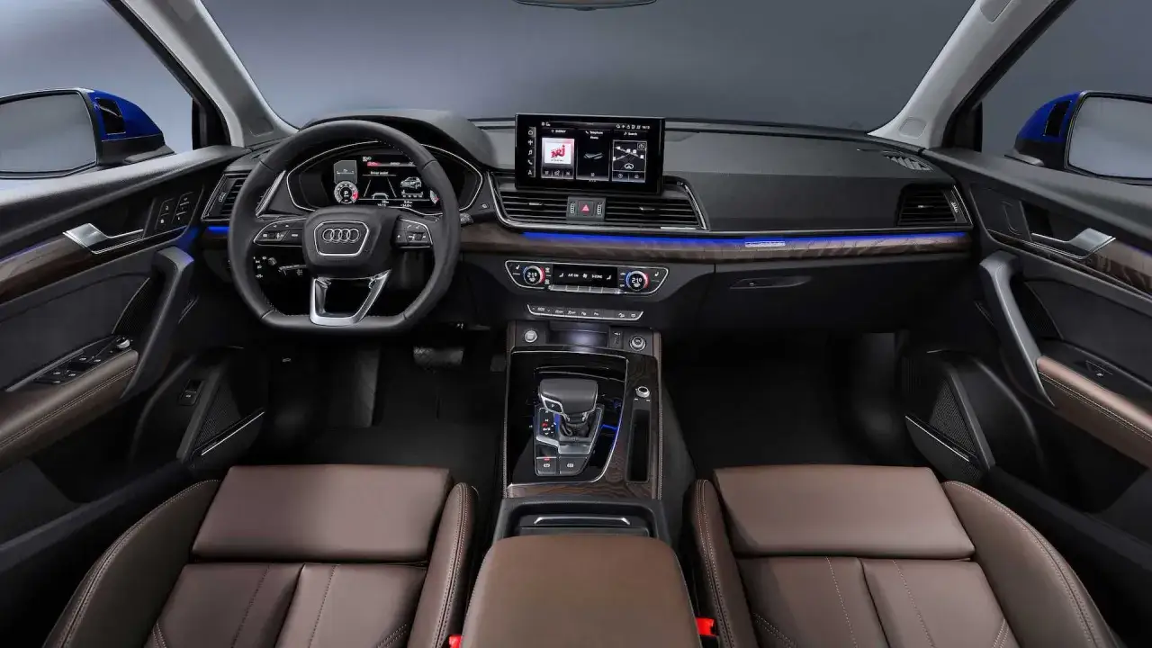 Wnętrze Audi Q5 Sportback: skórzana tapicerka, cyfrowe zegary, duży ekran multimediów i ambientowe oświetlenie.