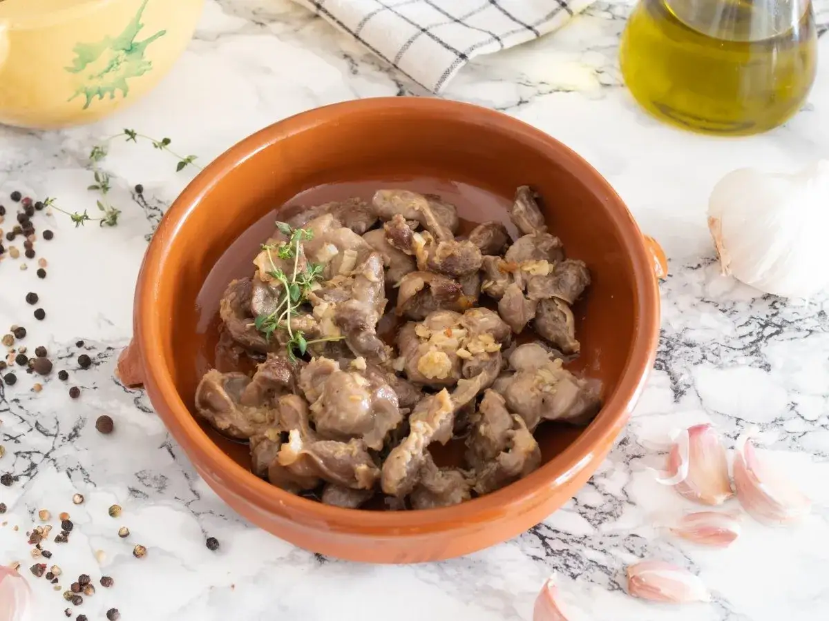 Mollejas de pollo al ajillo, tiernas y sabrosas, servidas en cazuela de barro con ajo y tomillo.