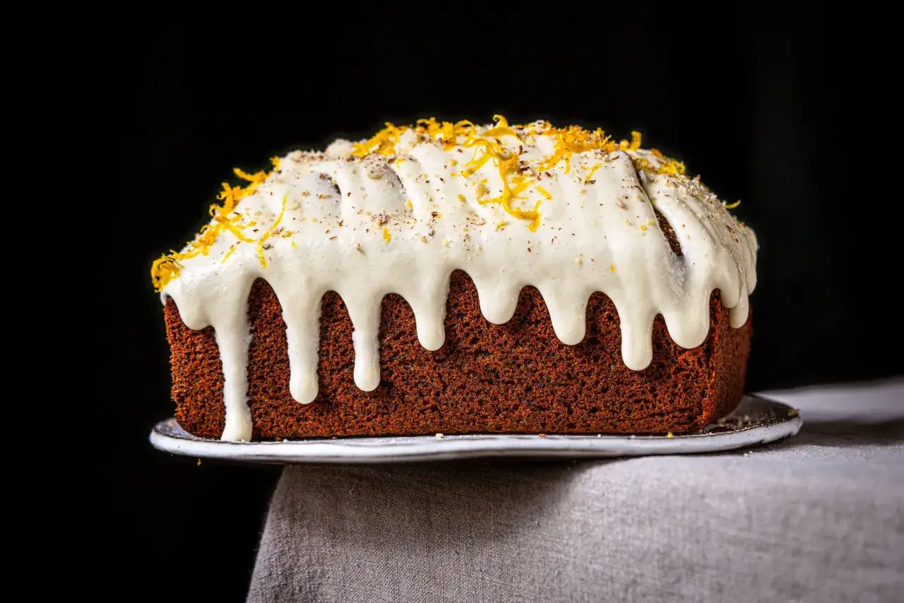Saftiger Kuchen mit weißem Zuckerguss und Orangenzesten, perfekt für ein Mohntorte Rezept.