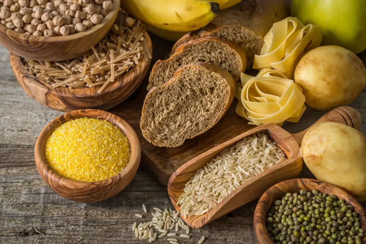 R&oacute;żnorodne produkty bogate w węglowodany: ciecierzyca, makaron, ryż, chleb, ziemniaki, kukurydza i fasolka mung.