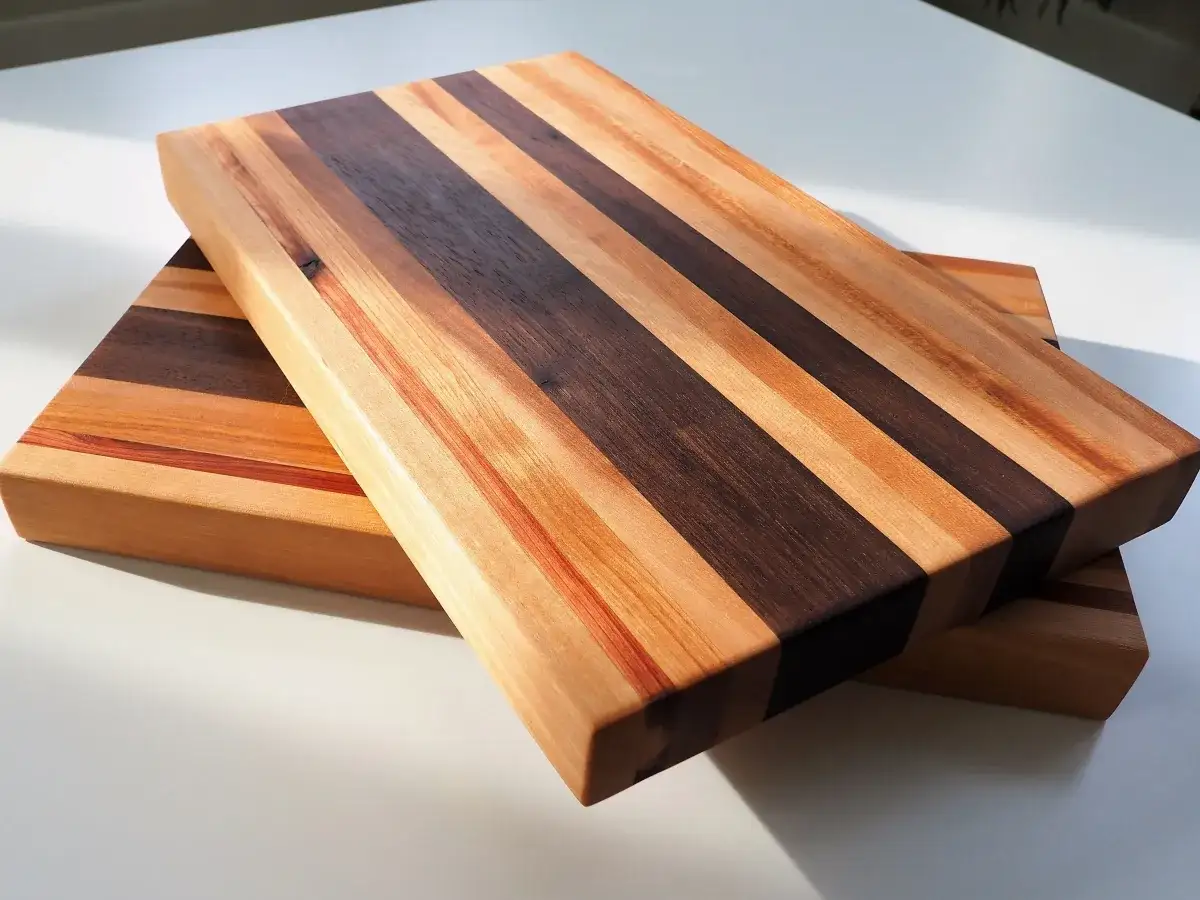 Two beautiful DIY cutting boards made of alternating light and dark wood stripes, ready for your kitchen.