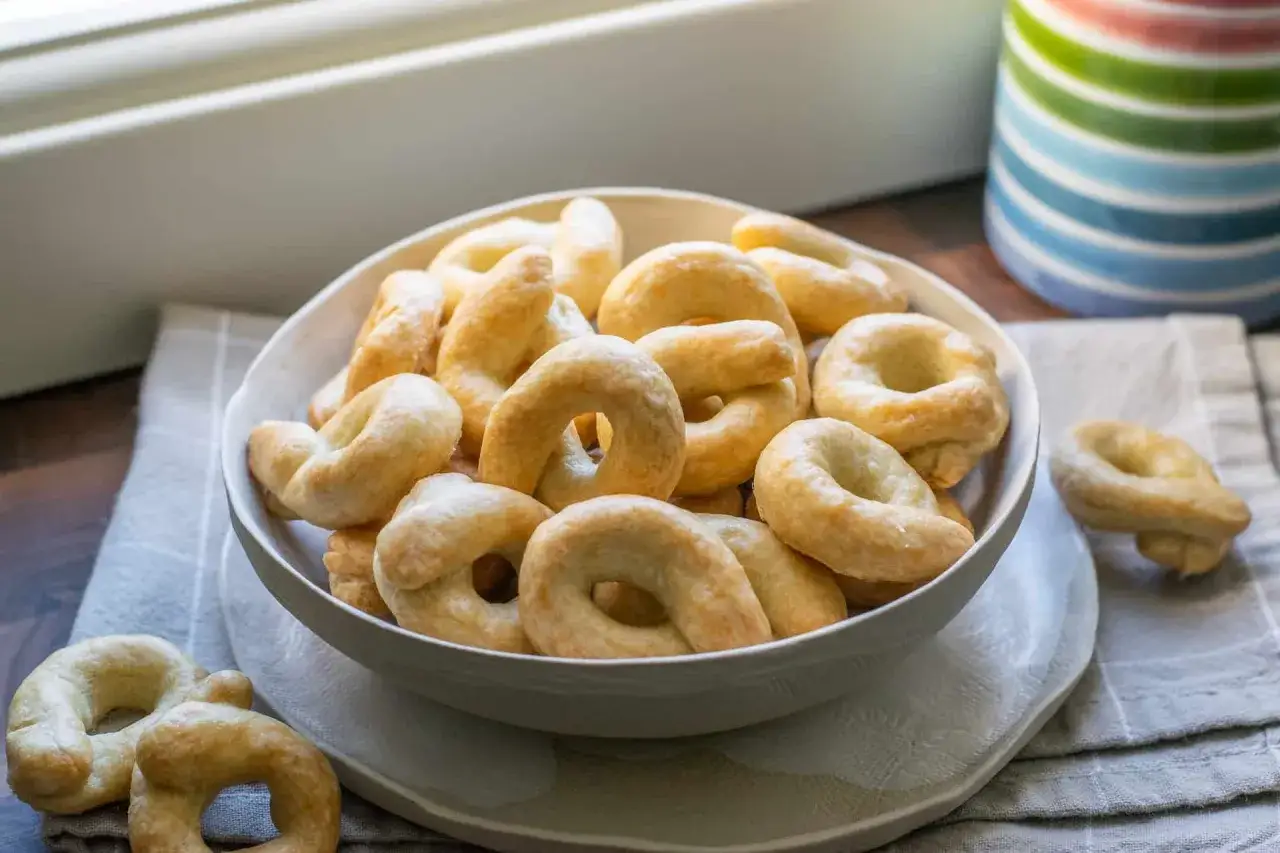 Una ciotola piena di friabili taralli salati al vino bianco, perfetti per uno snack croccante.