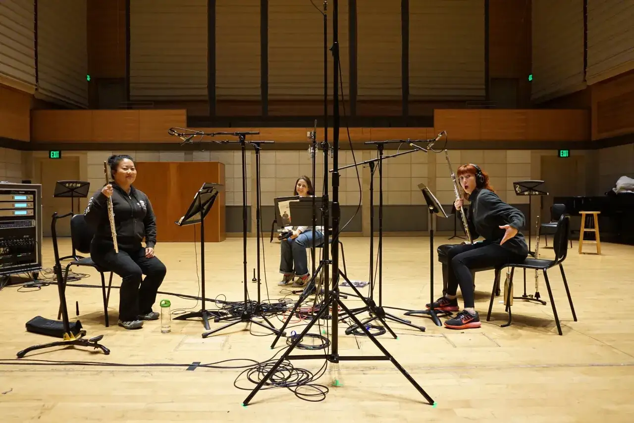 Drei Musikerinnen mit Flöten in einem Aufnahmestudio, bereit, mit Musik Geld zu verdienen.