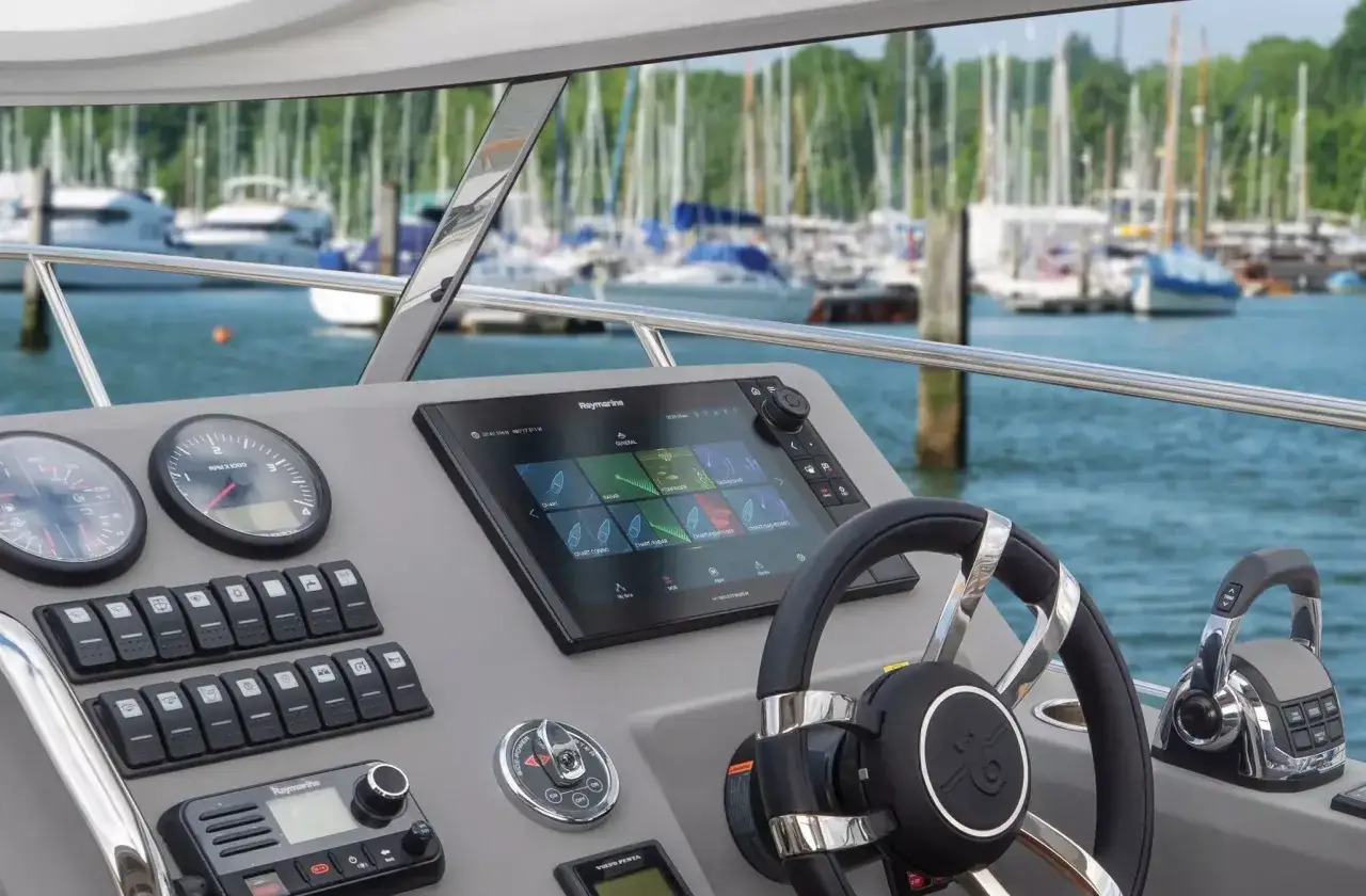 Cruscotto di uno yacht con strumenti e schermo multifunzione. La posizione yacht è perfetta per navigare tra le barche ormeggiate.