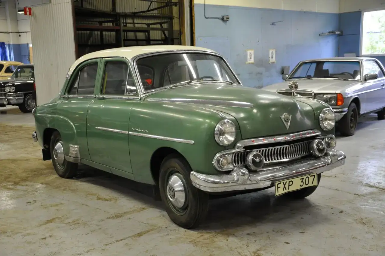 Grön Vauxhall Velox med vitt tak står i ett garage. En silverfärgad bil syns i bakgrunden.