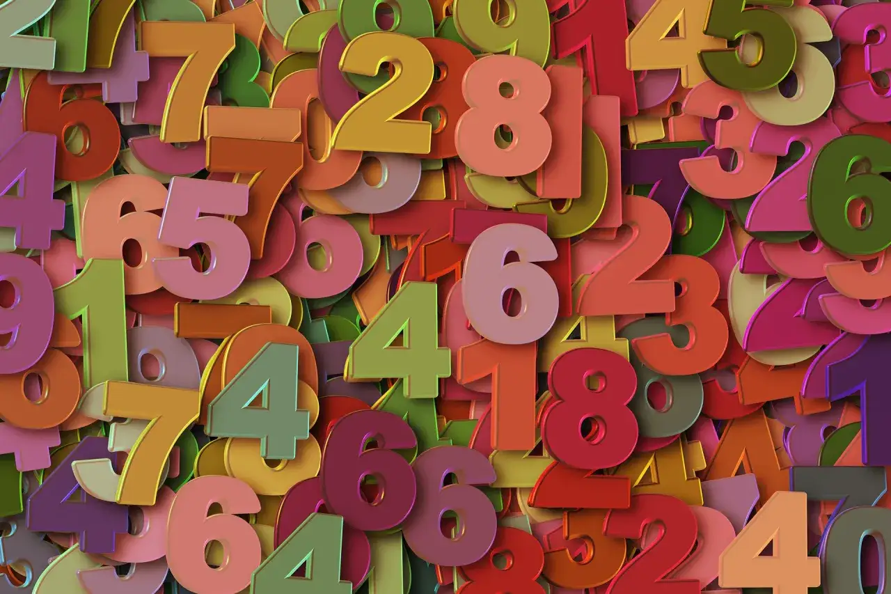 Kolorowe cyfry tworzą gęsty wzór. Wśród nich widać liczbę 3, symbolizującą 3 rok numerologiczny, pełen kreatywności i ekspresji.