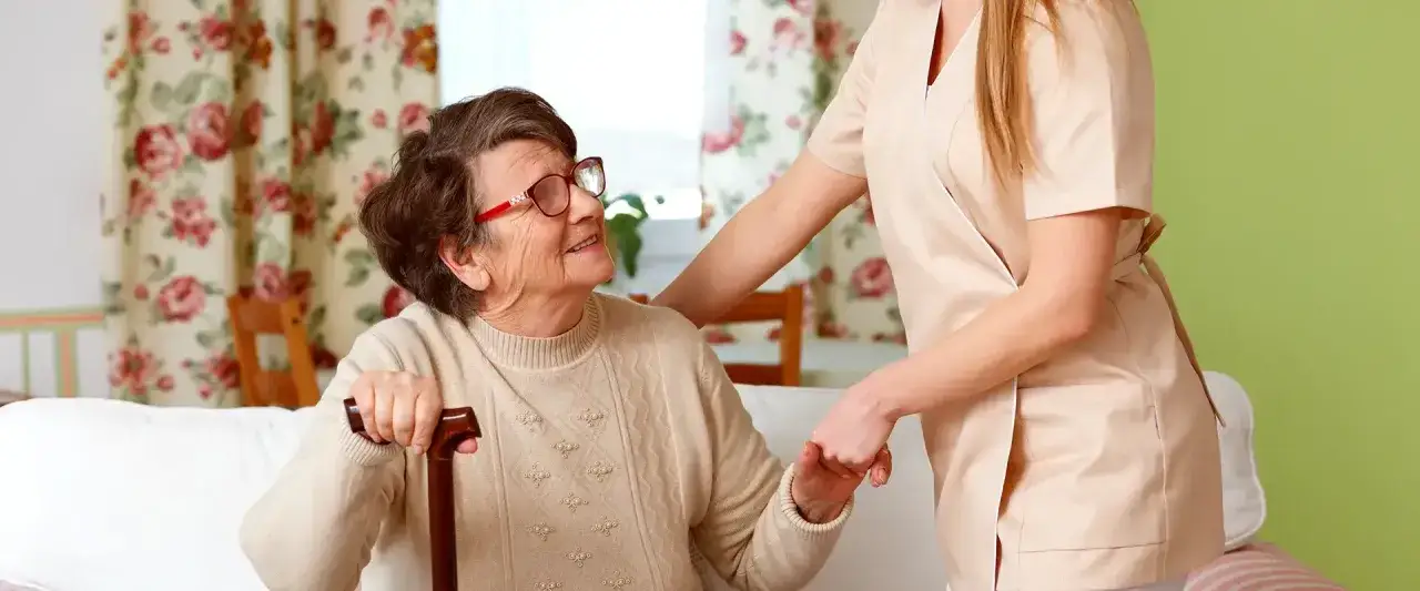 Eine Pflegekraft unterstützt eine ältere Dame mit Pflegegrad 3. Die zumutbare Arbeitszeit für solche Einsätze ist wichtig.