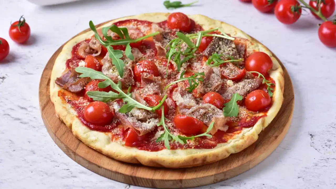Pizza z mąki kokosowej, pomidorkami, rukolą i szynką. Idealna na zdrowe przepisy!