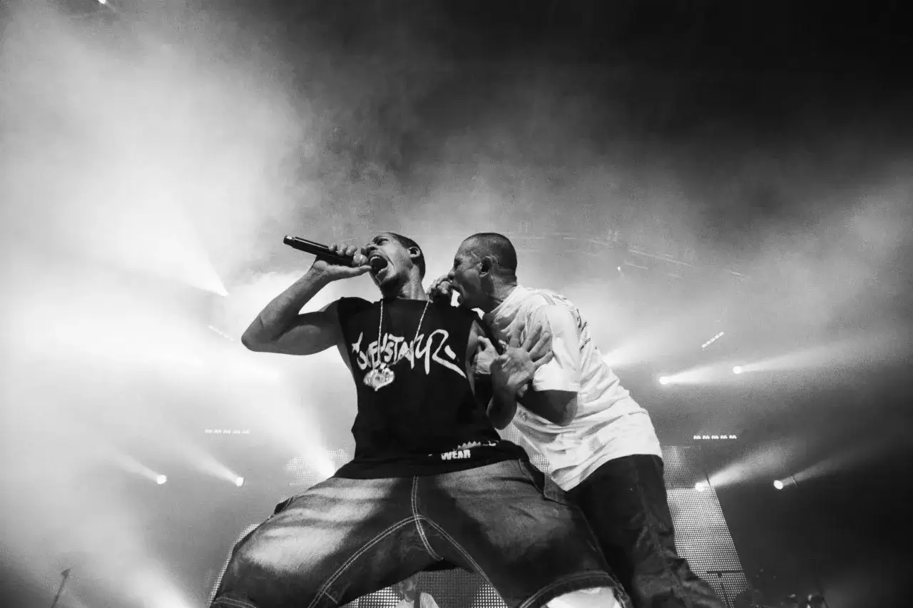 Deux rappeurs sur sc&egrave;ne, l'un tenant un micro, incarnent la diversit&eacute; des diff&eacute;rents styles de rap fran&ccedil;ais.