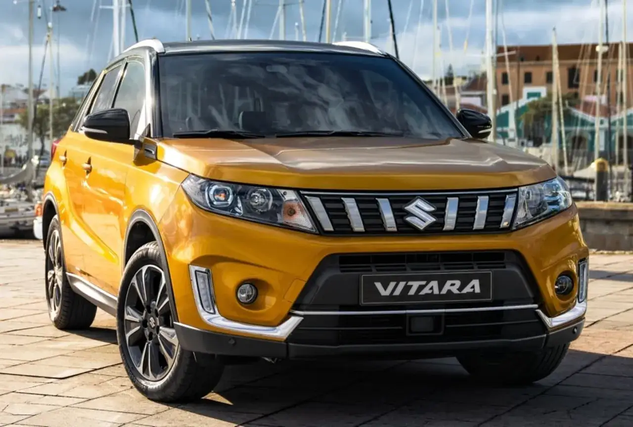 Un Suzuki Vitara amarillo brillante listo para una prueba de manejo en un puerto deportivo.
