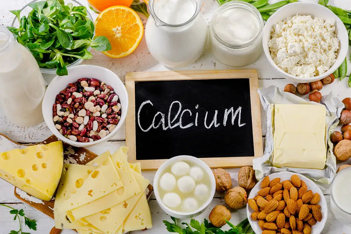 Vielf&auml;ltige Lebensmittel mit Calcium: Milchprodukte, K&auml;se, N&uuml;sse, Bohnen und gr&uuml;nes Gem&uuml;se.