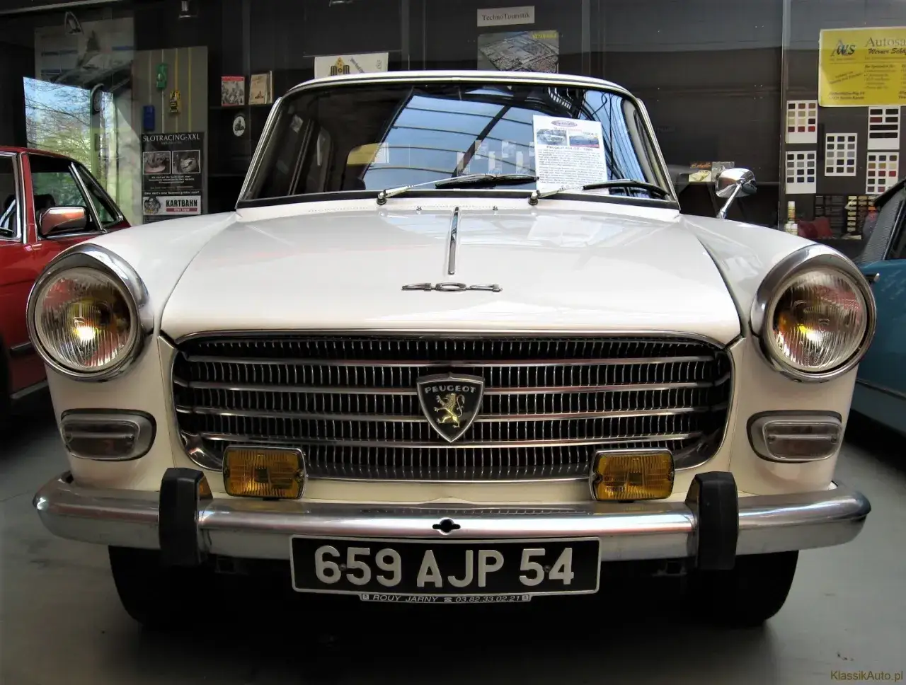 Biały Peugeot 404 z chromowanym grillem i okrągłymi reflektorami. Tablica rejestracyjna 659 AJP 54.