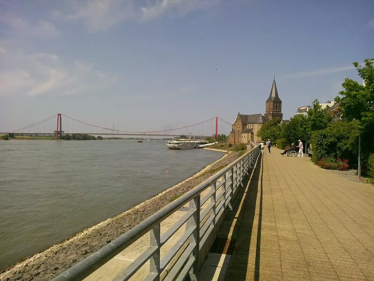 Spaziergang an der **Rheinpromenade Emmerich** mit Blick auf die imposante Br&uuml;cke und die Kirche.