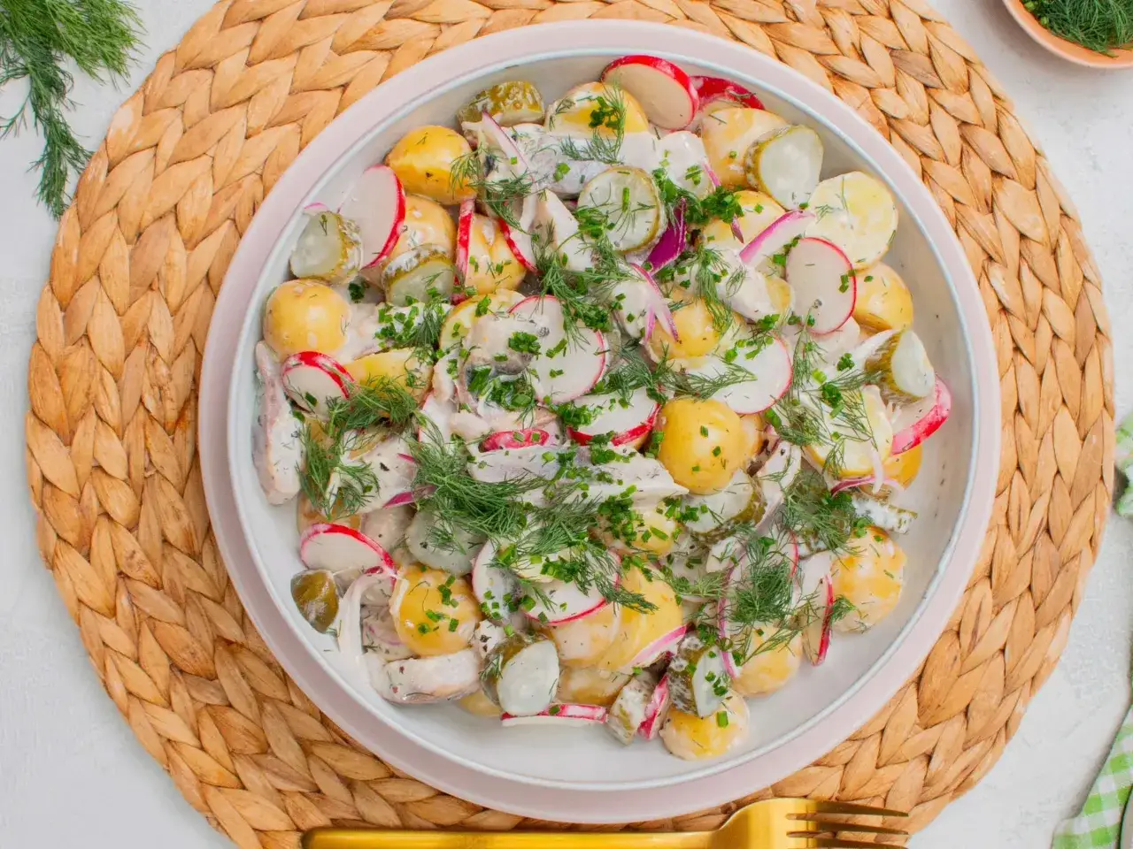 Kartoffelsalat mal anders: cremiger Kartoffelsalat mit Radieschen, Gurken und frischem Dill, garniert mit Schnittlauch.