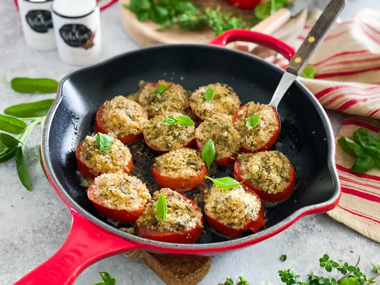 Pomodori gratinati in padella, ripieni e dorati, guarniti con basilico fresco. Un piatto invitante e saporito.