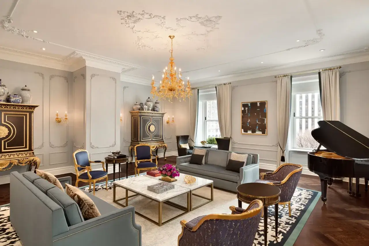 Elegancki salon z fortepianem i widokiem na miasto. Sprawdź hotel Plaza Nowy Jork ceny, by poczuć ten luksus.