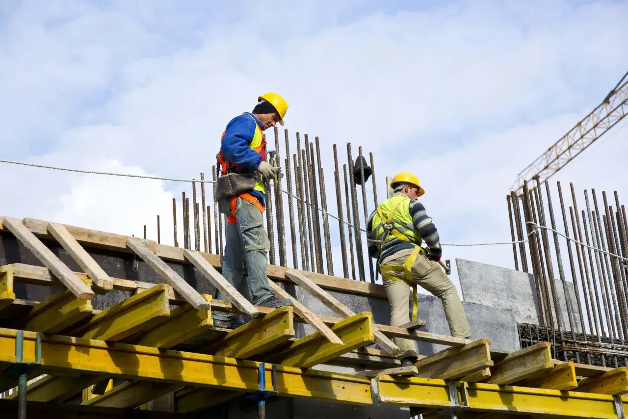 Operai in cantiere, su impalcature precarie, con imbracature di sicurezza. Da qui possiamo evincere il rischio dell'attivit&agrave; lavorativa in quota.