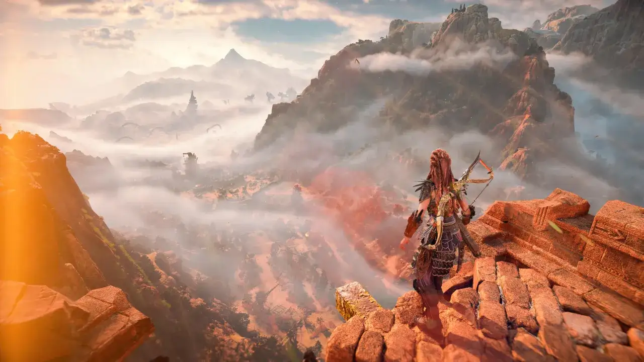 Aloy z łukiem na skale, spogląda na mglistą dolinę pełną maszyn. Krajobraz z Horizon Zero Dawn 2.