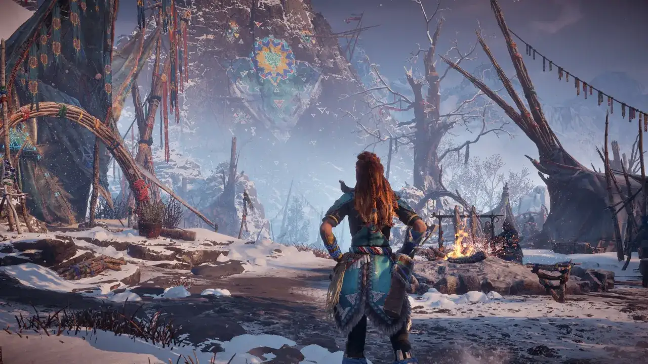 Aloy w zimowej scenerii, obozowisko z namiotami i ogniskiem. W tle góry i malowidło na skale. To dodatek do Horizon Zero Dawn.