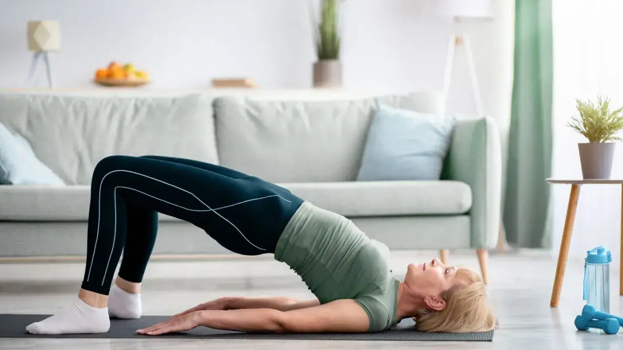 Frau macht eine Br&uuml;cke auf einer Matte, eine &Uuml;bung, die als Wunderwaffe gegen Arthrose gilt.