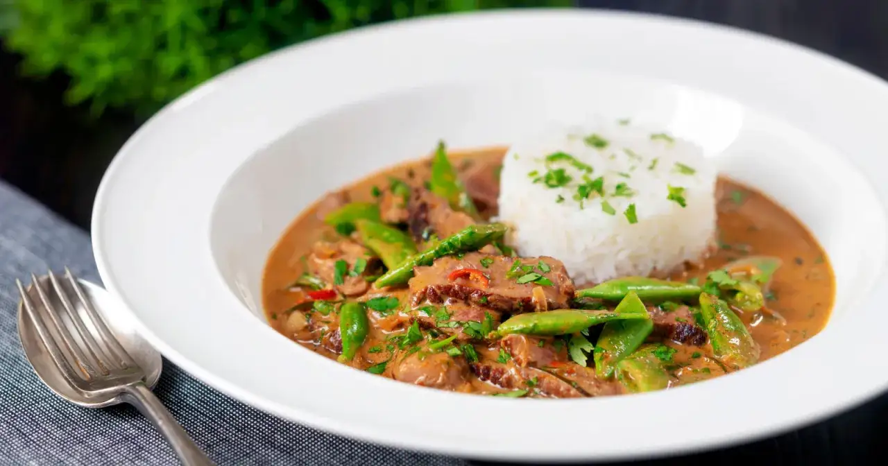 Ein köstliches Thai Curry mit Rindfleisch, knackigen grünen Bohnen und duftendem Reis, garniert mit frischer Petersilie.