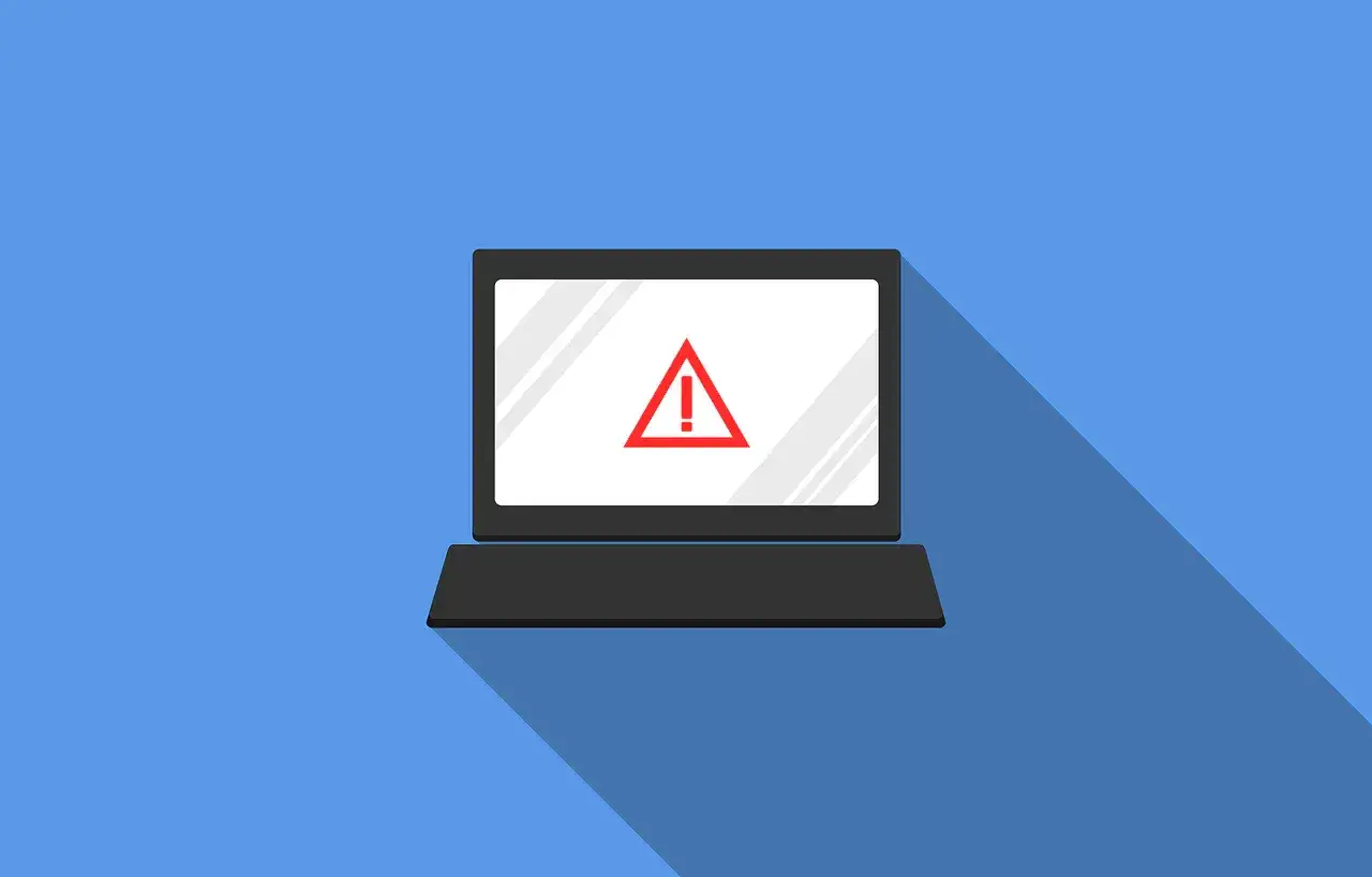 Laptop z czerwonym znakiem ostrzegawczym na ekranie. Może to oznaczać problem z firewallem lub inną awarię systemu.