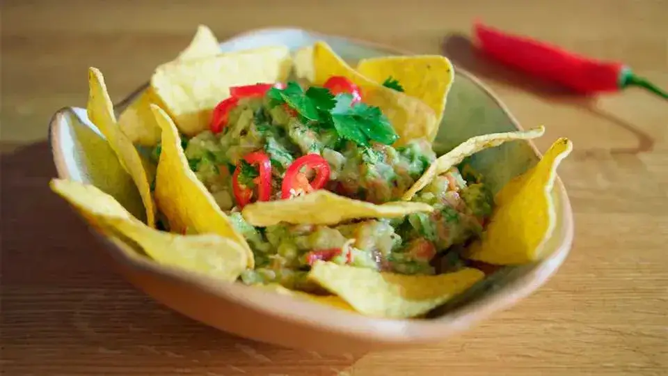 gotowe guacamole z pomidorem w misce z nachos